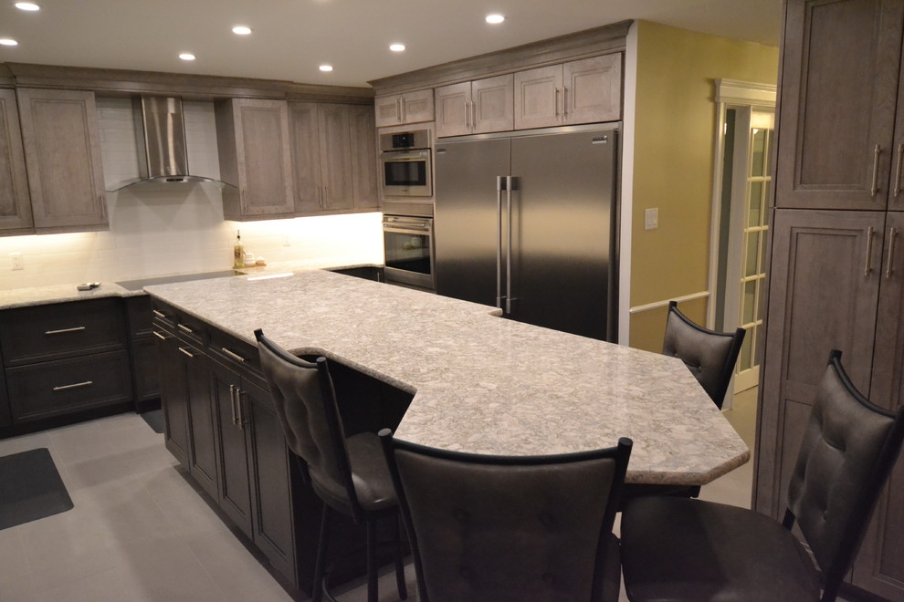 Eat-in kitchen - mid-sized transitional u-shaped eat-in kitchen idea in Toronto with recessed-panel cabinets and an island