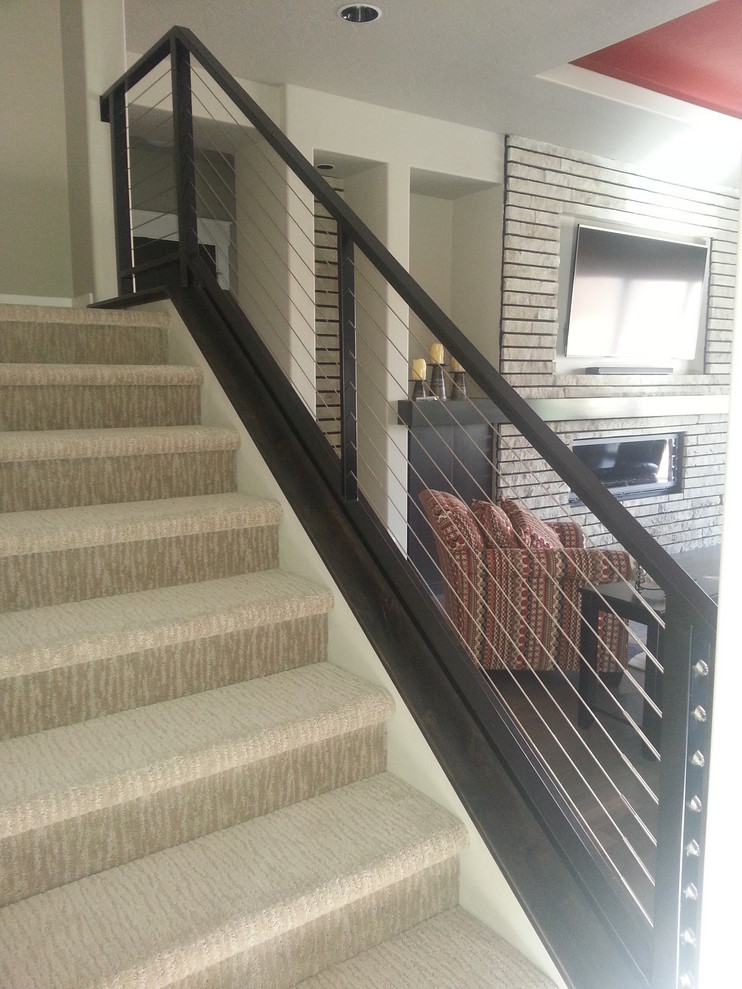 Photo of a large modern carpeted u-shaped staircase in Boise with carpet risers and cable railing.