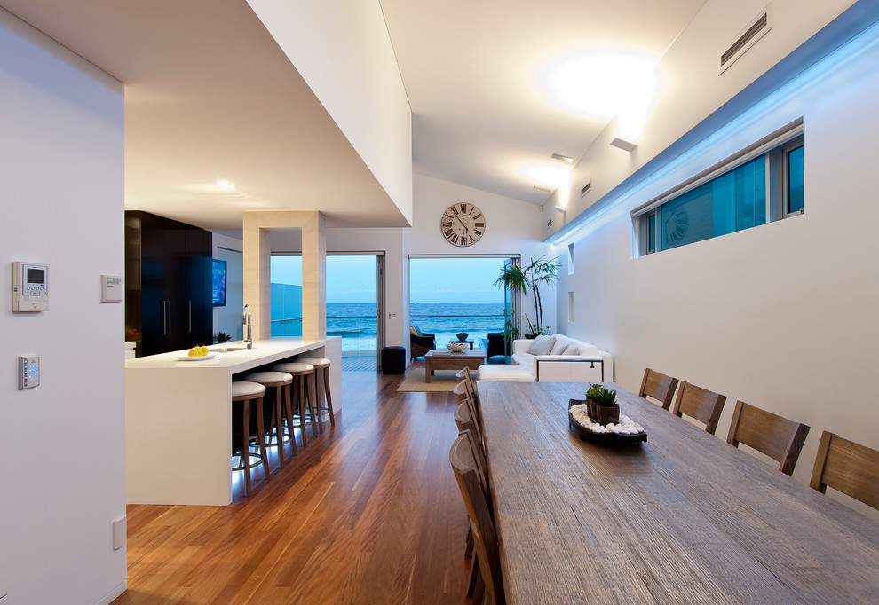 Photo of a mid-sized contemporary open plan dining in Sydney with white walls and medium hardwood floors.