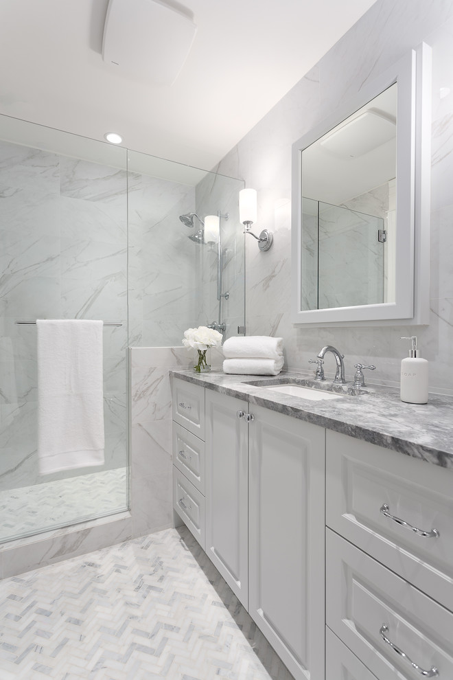 Photo of a mid-sized traditional 3/4 bathroom in Vancouver with recessed-panel cabinets, white cabinets, white tile, porcelain tile, white walls, porcelain floors, engineered quartz benchtops, grey floor and grey benchtops.