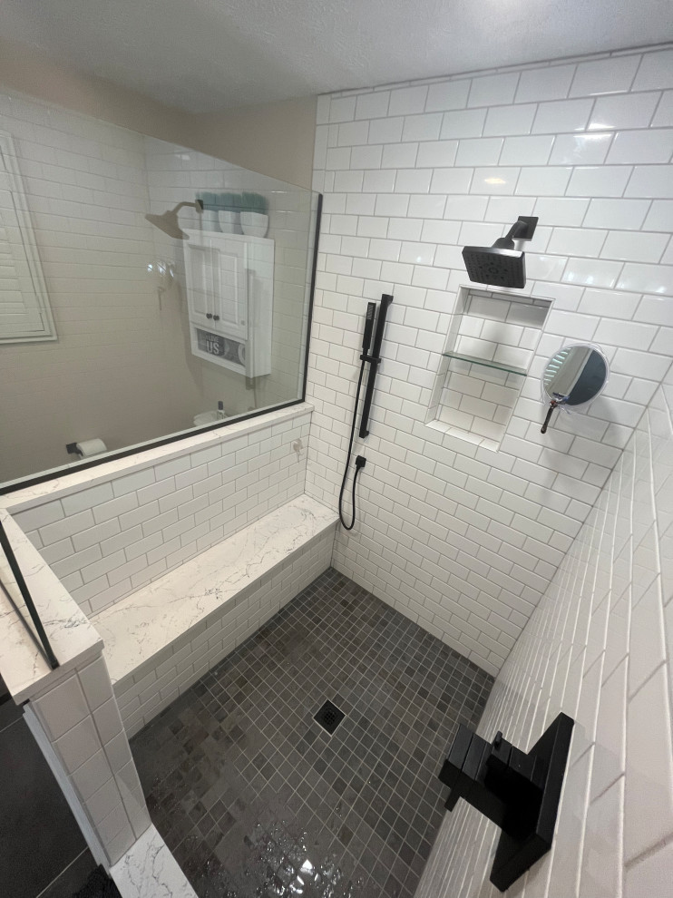 Inspiration for a mid-sized country master bathroom in Indianapolis with shaker cabinets, white cabinets, a corner shower, a two-piece toilet, white tile, subway tile, beige walls, porcelain floors, an undermount sink, quartzite benchtops, grey floor, a hinged shower door, white benchtops, a niche, a single vanity and a built-in vanity.