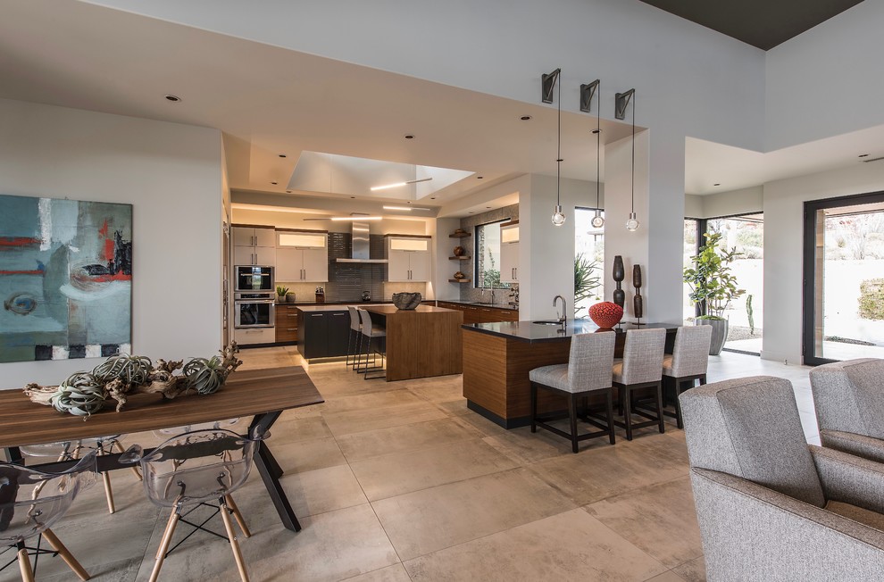 Inspiration for a large contemporary u-shaped eat-in kitchen in Phoenix with flat-panel cabinets, multiple islands, an undermount sink, dark wood cabinets, solid surface benchtops, grey splashback, glass tile splashback, panelled appliances, cement tiles, grey floor and black benchtop.