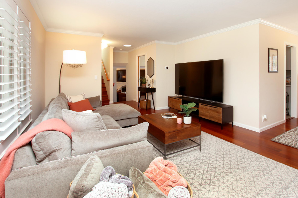 Diseño de salón cerrado vintage de tamaño medio con paredes beige, suelo de madera oscura, televisor independiente y suelo rojo