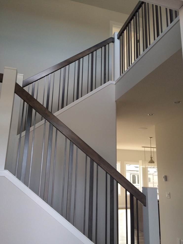 Example of a mid-sized transitional u-shaped mixed material railing staircase design in Calgary