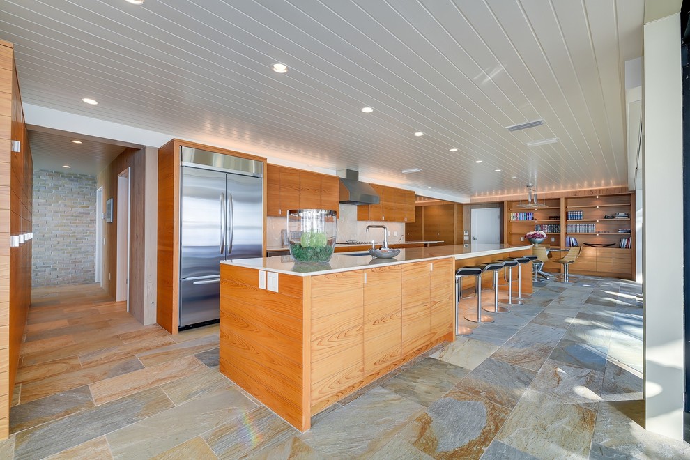 Inspiration for a large midcentury galley eat-in kitchen in Austin with flat-panel cabinets, stainless steel appliances, slate floors, with island, onyx benchtops and stone slab splashback.