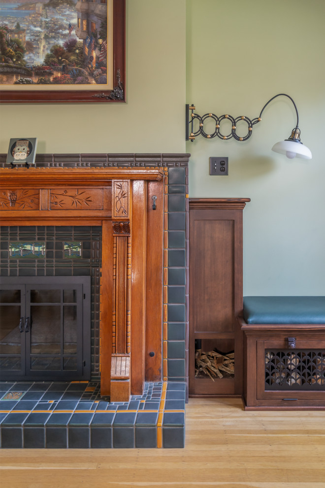 На фото: открытая гостиная комната среднего размера в стиле кантри с зелеными стенами, светлым паркетным полом, фасадом камина из дерева и стандартным камином с