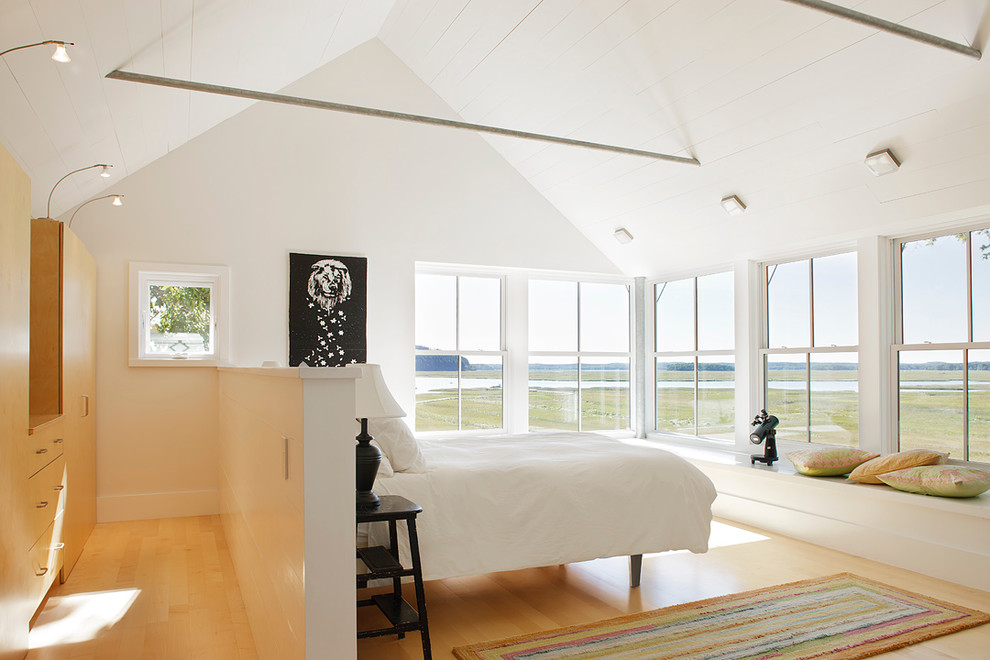 Photo of a country bedroom in Boston with white walls and light hardwood floors.