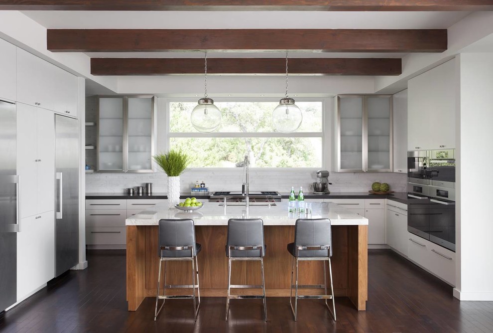 Inspiration for a contemporary l-shaped kitchen in Austin with an undermount sink, flat-panel cabinets, white cabinets, white splashback, stainless steel appliances, dark hardwood floors and with island.