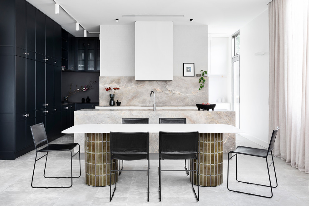 Contemporary l-shaped open plan kitchen in Melbourne with an undermount sink, black cabinets, grey splashback, stone slab splashback, with island, grey floor and grey benchtop.