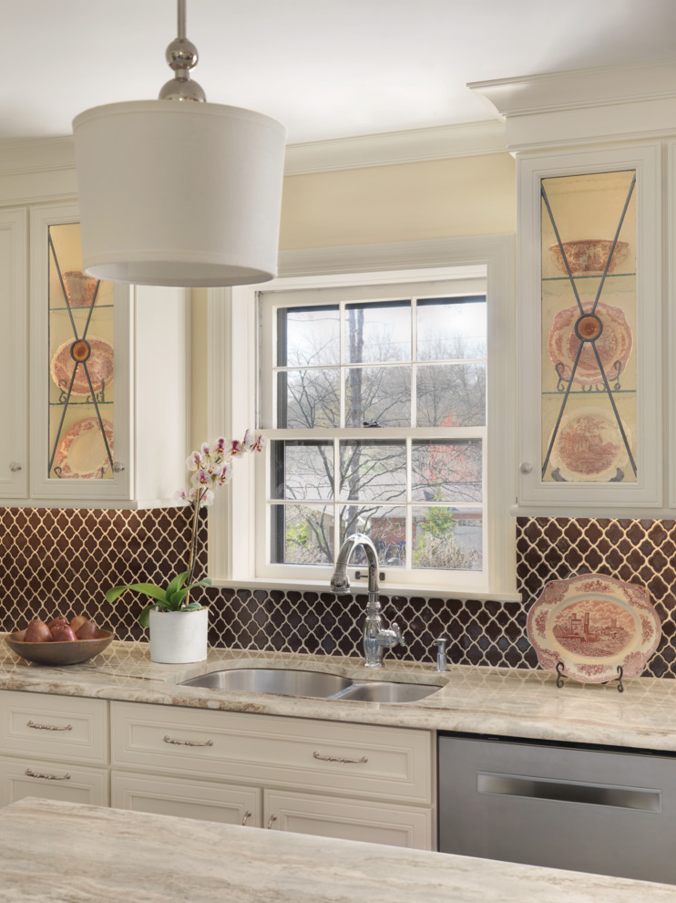 Inspiration for a transitional kitchen remodel in St Louis with white cabinets, granite countertops, brown backsplash and an island