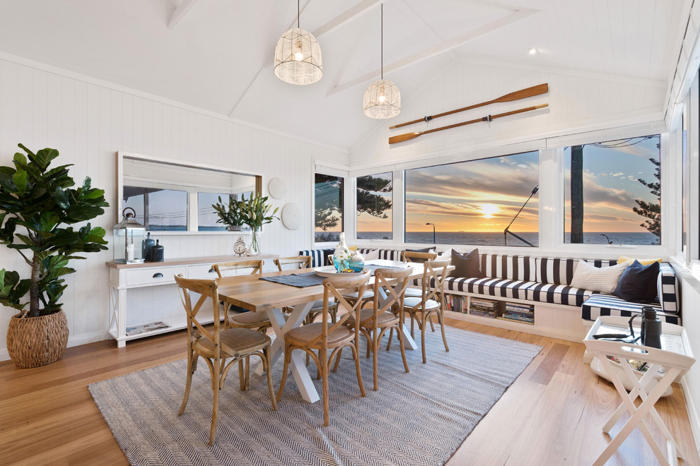 Large beach style dining room in Perth with white walls, medium hardwood floors and brown floor.