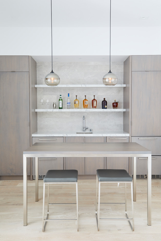 Design ideas for a contemporary single-wall wet bar in San Francisco with an undermount sink, flat-panel cabinets, light wood cabinets, white splashback, light hardwood floors and beige floor.