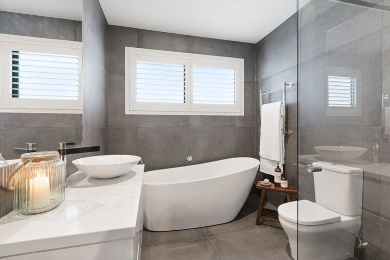 Design ideas for a mid-sized contemporary master bathroom in Melbourne with white cabinets, a freestanding tub, a corner shower, grey walls, engineered quartz benchtops and grey floor.