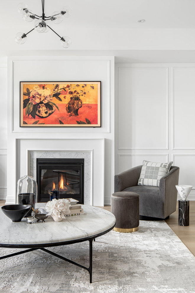Photo of a large contemporary open plan living room in Toronto with white walls, light hardwood flooring, a standard fireplace, a wooden fireplace surround, a wall mounted tv, white floors and wainscoting.