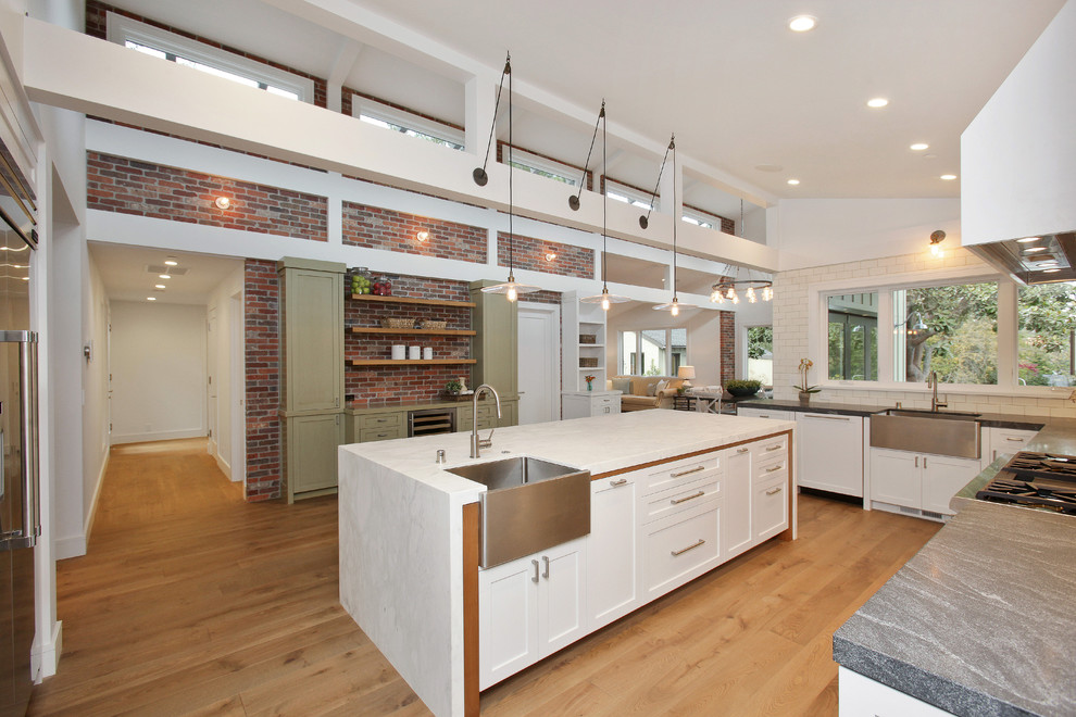 This is an example of a country separate kitchen in San Francisco with a farmhouse sink, shaker cabinets, white cabinets, white splashback, subway tile splashback and stainless steel appliances.