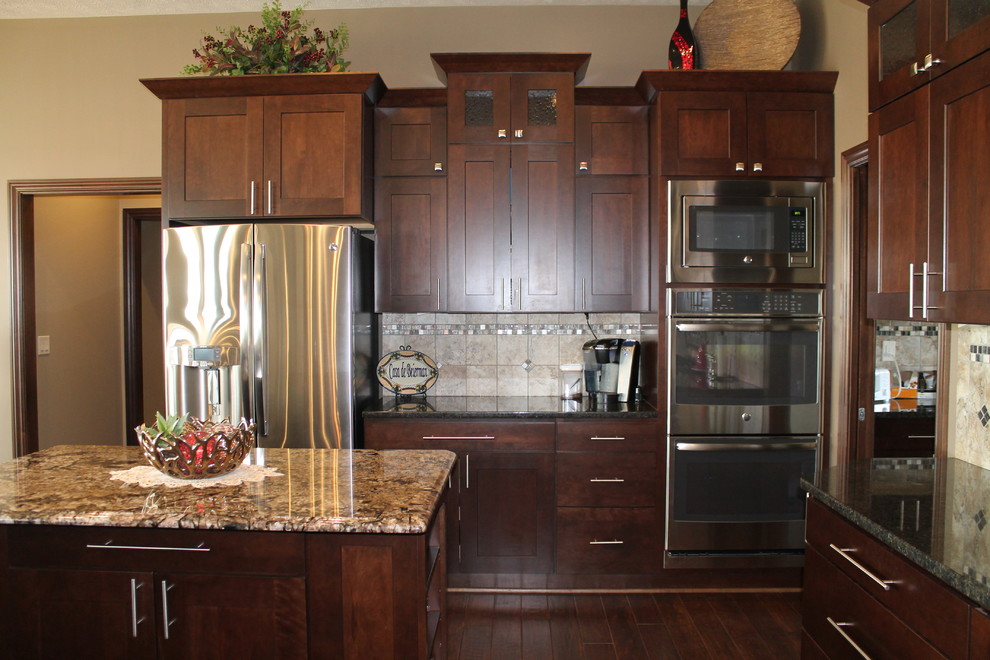 Inspiration for a large single-wall dark wood floor open concept kitchen remodel with an undermount sink, flat-panel cabinets, dark wood cabinets, granite countertops, beige backsplash, stainless steel appliances, beige walls and two islands