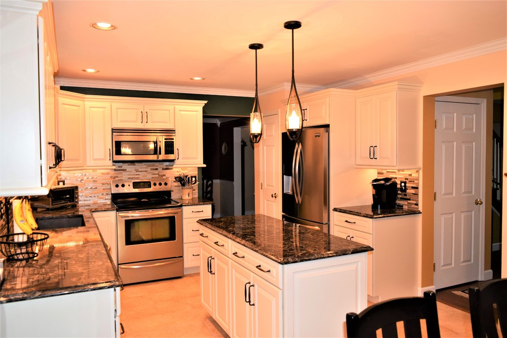 Kitchen - transitional ceramic tile kitchen idea with an undermount sink, raised-panel cabinets, white cabinets, quartz countertops, glass tile backsplash, stainless steel appliances, an island and black countertops