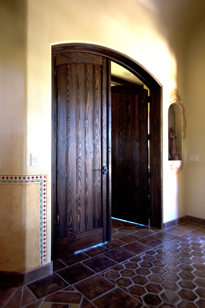 Mid-sized country front door in San Luis Obispo with yellow walls, ceramic floors, a double front door and a dark wood front door.