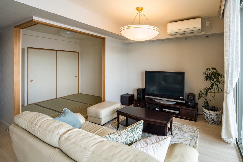 Photo of a mid-sized traditional living room in Yokohama with beige walls, light hardwood floors, no fireplace, a freestanding tv, beige floor, wallpaper and wallpaper.