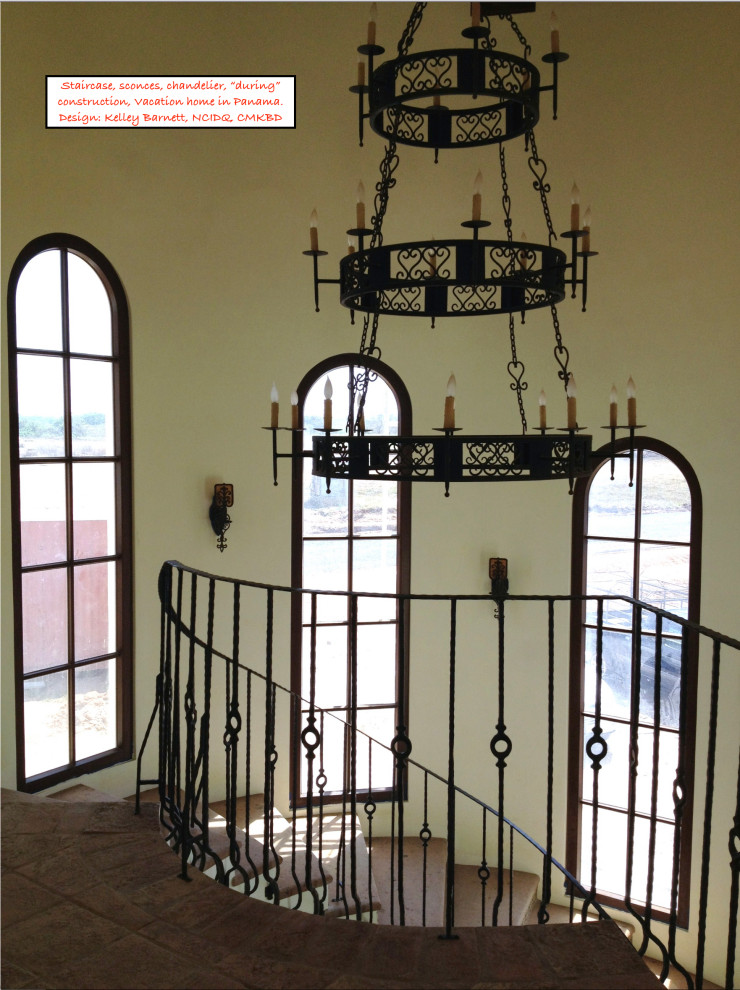 На фото: большая изогнутая лестница в средиземноморском стиле с ступенями из известняка, подступенками из плитки и металлическими перилами