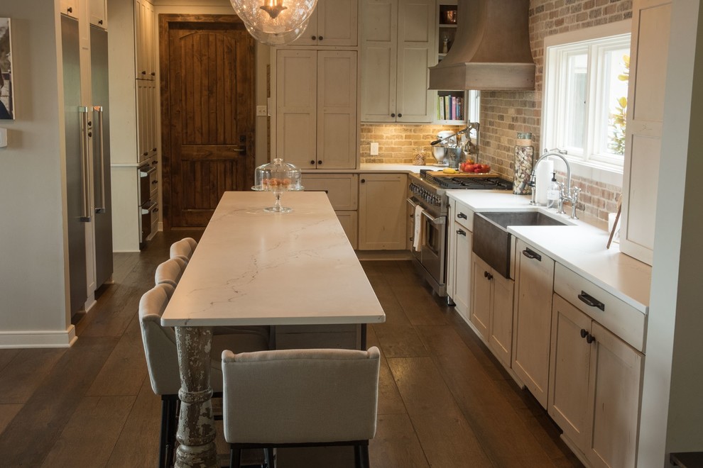 Inspiration for a large transitional galley dark wood floor and brown floor open concept kitchen remodel with a farmhouse sink, shaker cabinets, quartz countertops, brown backsplash, brick backsplash, stainless steel appliances and an island