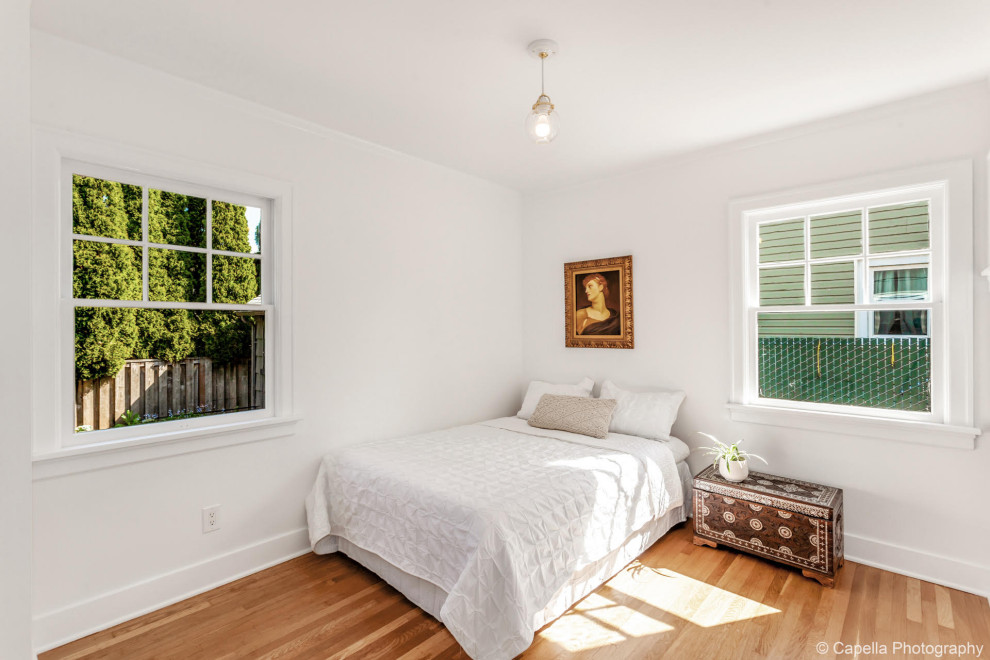Inspiration for a mid-sized arts and crafts guest bedroom in Portland with white walls and light hardwood floors.