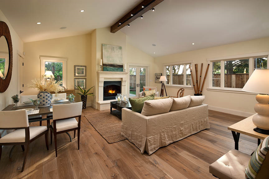 Photo of a mid-sized country formal open concept living room in Santa Barbara with beige walls, medium hardwood floors and a standard fireplace.