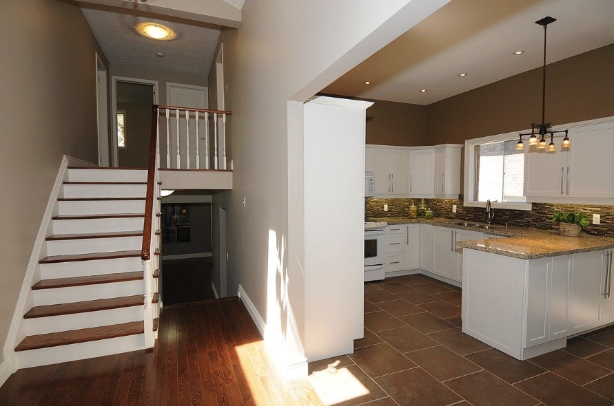 Photo of a mid-sized transitional wood straight staircase in Toronto with wood risers.