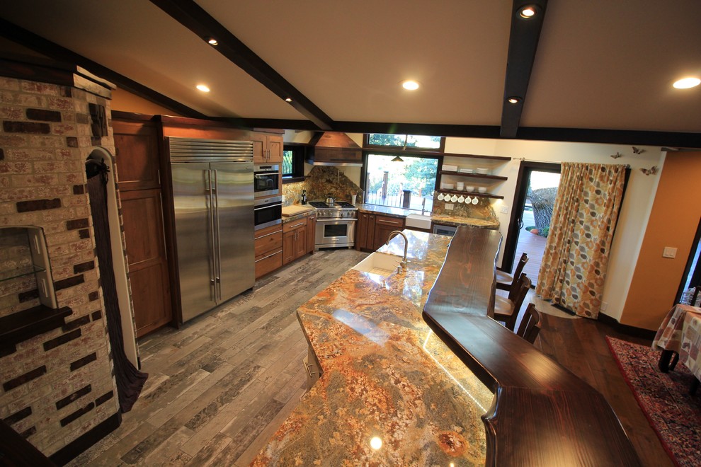 Inspiration for a large rustic l-shaped ceramic tile and gray floor kitchen pantry remodel in San Francisco with a farmhouse sink, raised-panel cabinets, distressed cabinets, granite countertops, multicolored backsplash, stone slab backsplash, stainless steel appliances and an island