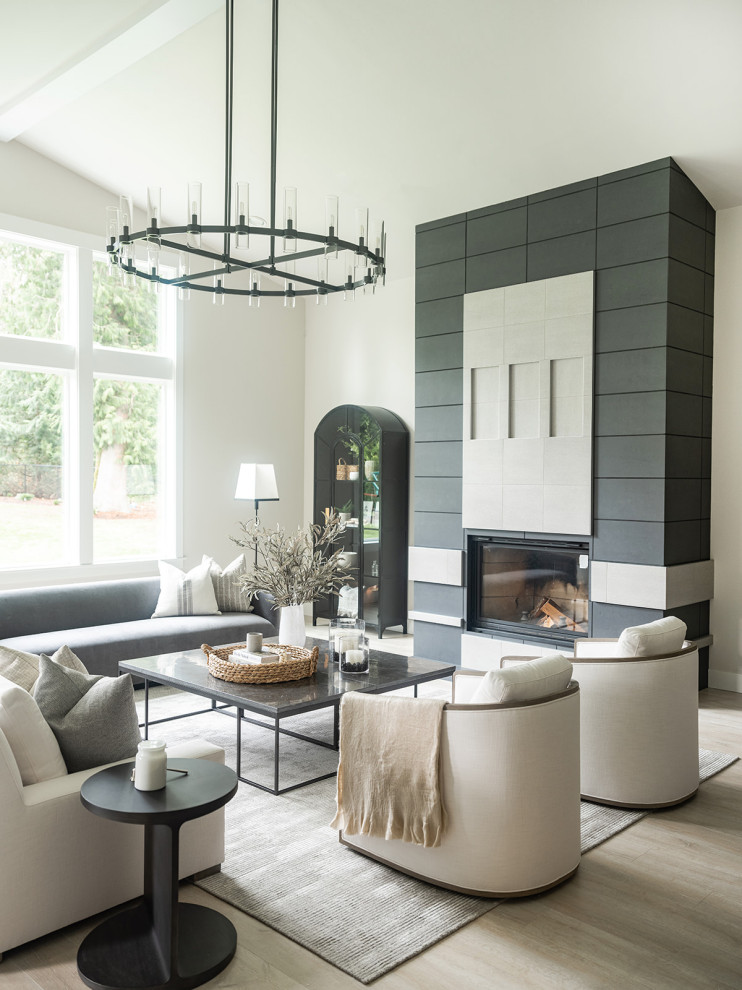 Inspiration for a transitional open concept living room in Seattle with white walls, light hardwood floors, a standard fireplace, beige floor and vaulted.