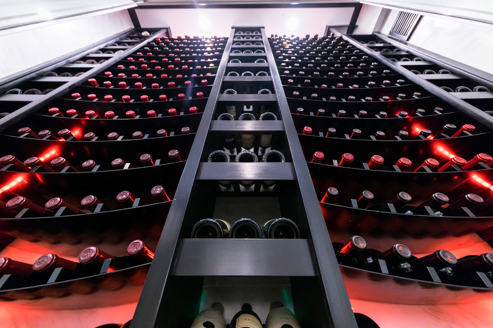 This is an example of a mid-sized modern wine cellar in New York with porcelain floors, display racks and grey floor.