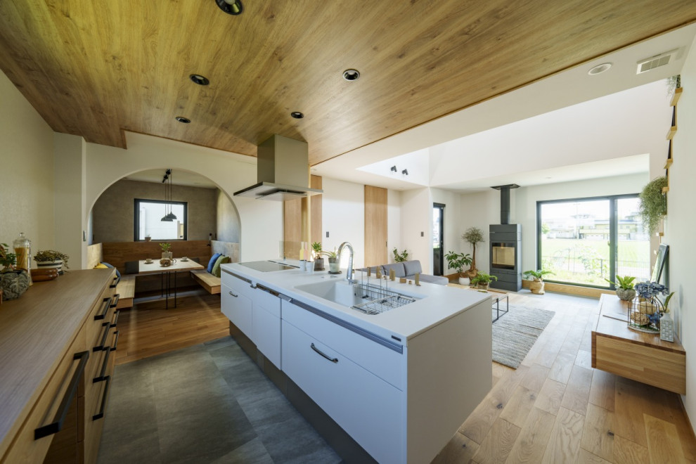 This is an example of a mid-sized asian single-wall eat-in kitchen in Other with an integrated sink, solid surface benchtops, white splashback, ceramic splashback, vinyl floors, with island, grey floor, brown benchtop and wallpaper.