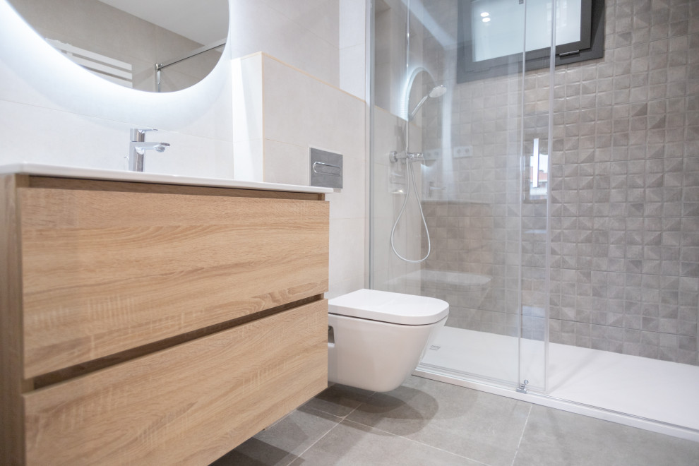 Example of a mid-sized trendy master beige tile and ceramic tile ceramic tile, gray floor and single-sink bathroom design in Barcelona with flat-panel cabinets, medium tone wood cabinets, a one-piece toilet, a trough sink, white countertops and a floating vanity