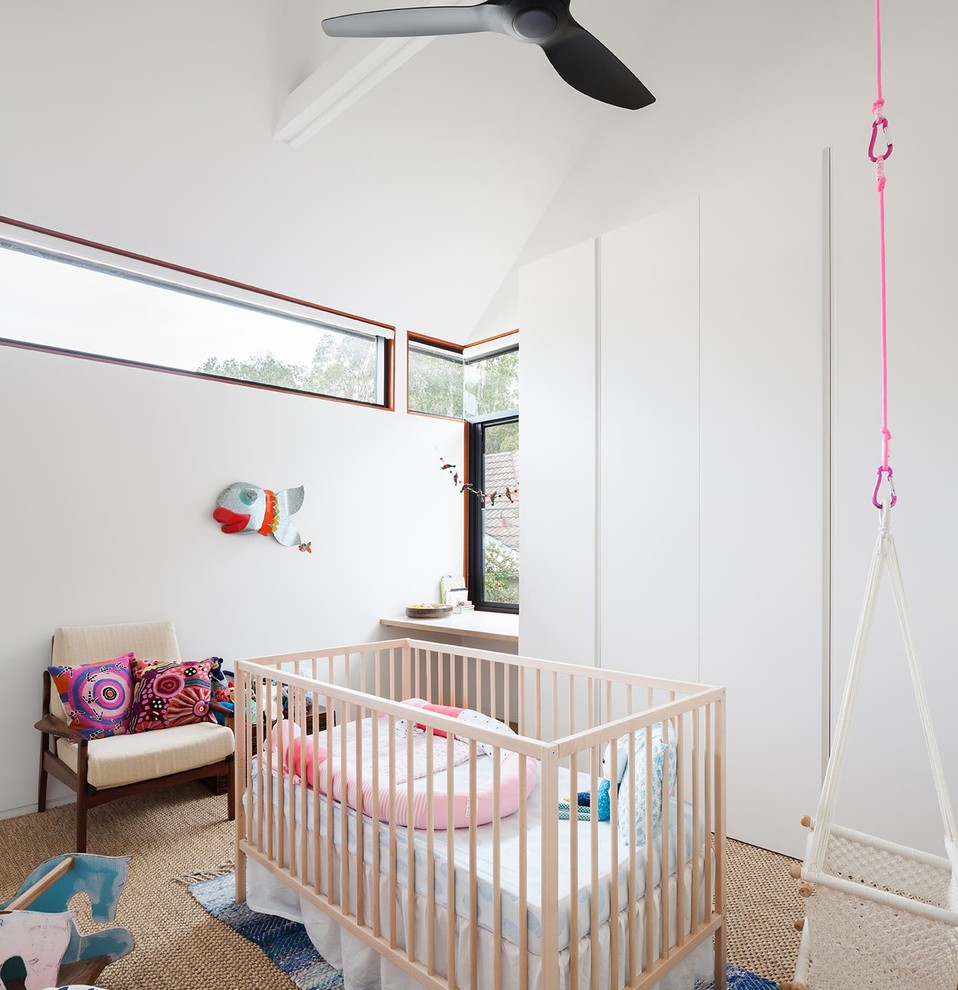 Mid-sized modern nursery in Sydney with white walls and carpet for girls.