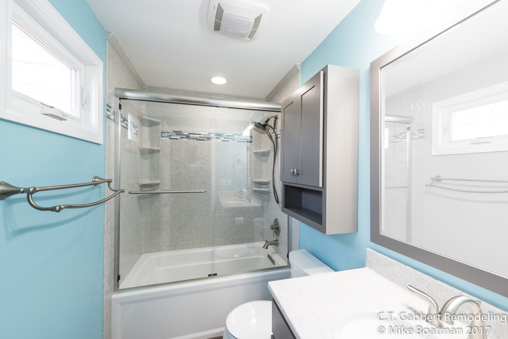 Inspiration for a mid-sized contemporary 3/4 bathroom in Chicago with beaded inset cabinets, grey cabinets, a drop-in tub, an alcove shower, blue walls, vinyl floors, an integrated sink, onyx benchtops, brown floor and a sliding shower screen.