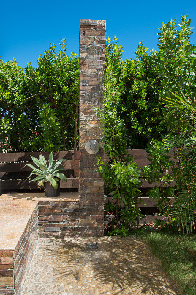 Tropical patio in Other with no cover and an outdoor shower.