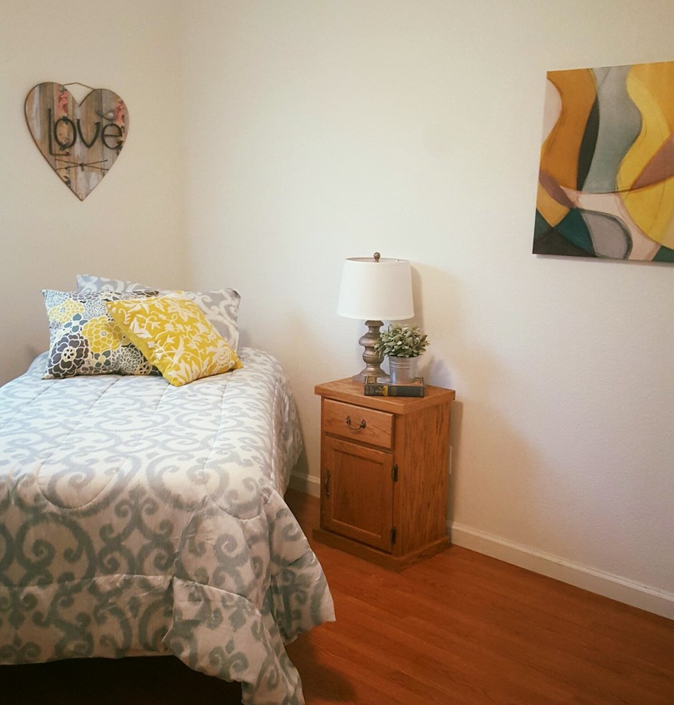 Idée de décoration pour une petite chambre d'amis tradition avec un mur blanc, aucune cheminée et un sol marron.