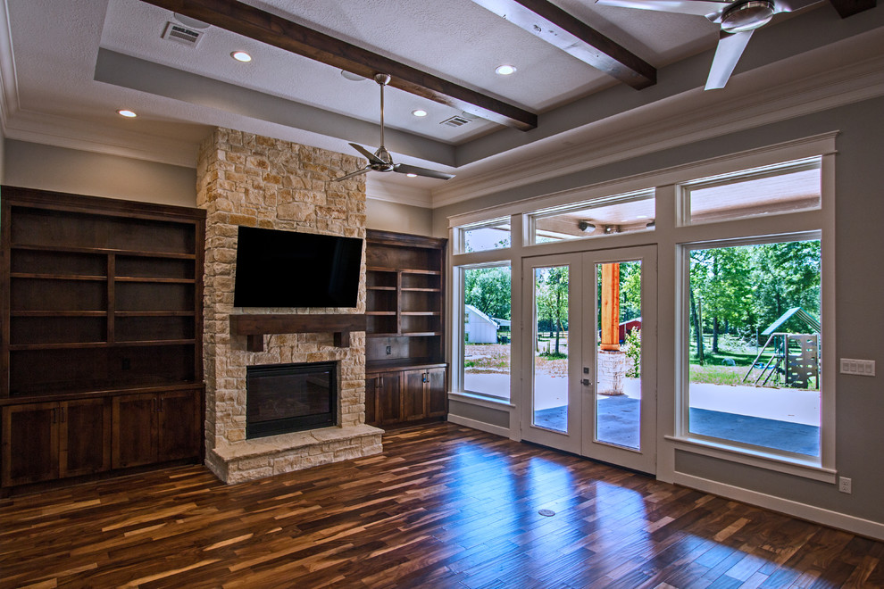 This is an example of a large transitional formal enclosed living room in Houston with grey walls, light hardwood floors, a standard fireplace, a stone fireplace surround, a wall-mounted tv and multi-coloured floor.