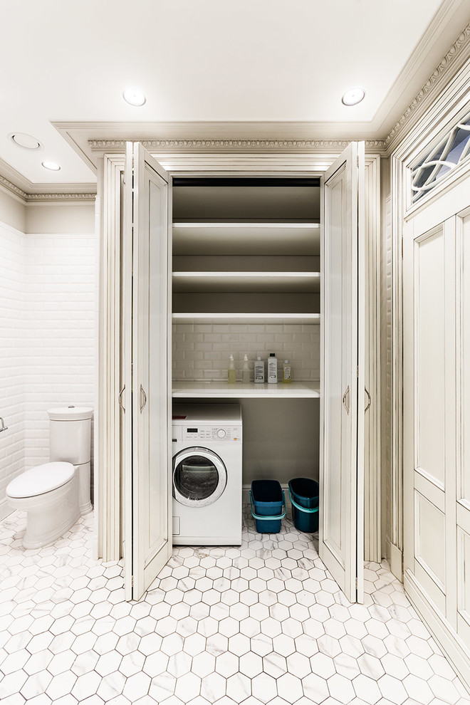 This is an example of a traditional laundry room in Moscow with white cabinets.