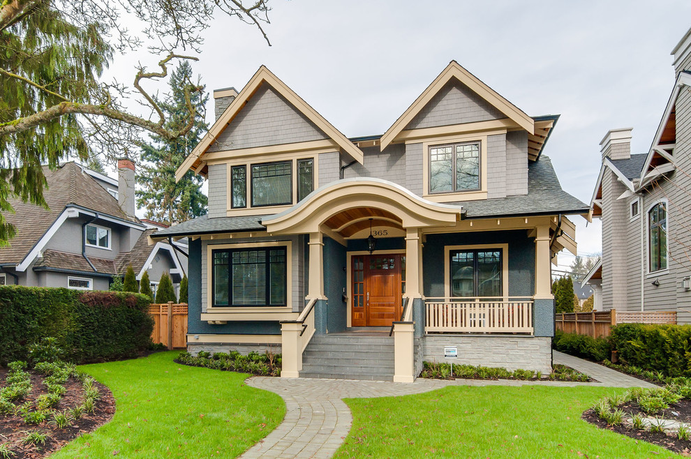This is an example of an arts and crafts two-storey multi-coloured house exterior in Vancouver with mixed siding, a gable roof and a shingle roof.