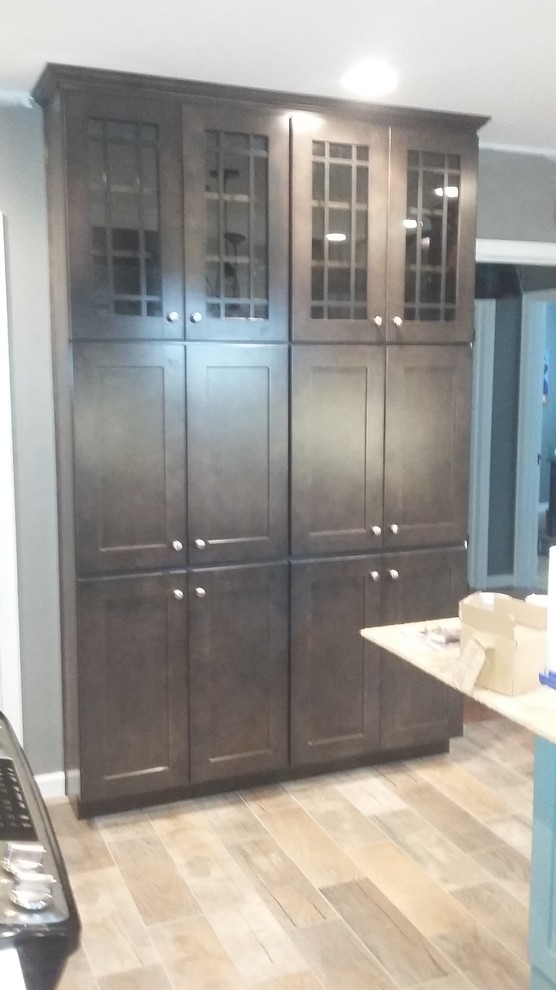 Mid-sized mountain style u-shaped porcelain tile eat-in kitchen photo in Indianapolis with a farmhouse sink, shaker cabinets, dark wood cabinets, wood countertops, white backsplash, ceramic backsplash, stainless steel appliances and an island