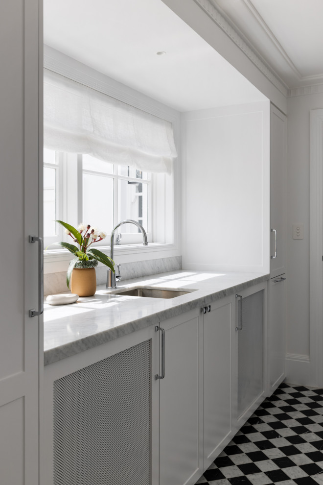 Design ideas for a large transitional single-wall dedicated laundry room in Sydney with an undermount sink, shaker cabinets, white cabinets, marble benchtops, white walls, marble floors, a concealed washer and dryer, multi-coloured floor and grey benchtop.