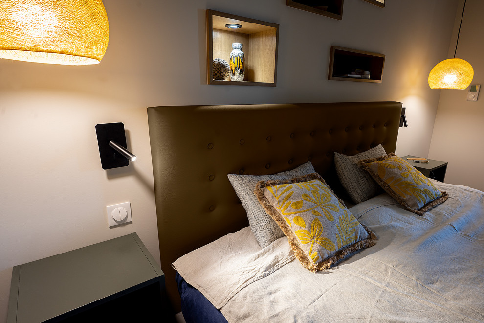 Ejemplo de dormitorio principal actual grande con paredes beige, suelo de baldosas de terracota, suelo marrón y papel pintado