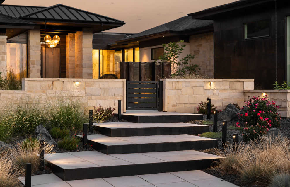 Design ideas for a large contemporary front yard full sun xeriscape for summer in Denver with natural stone pavers and a stone fence.