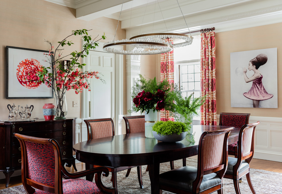 This is an example of a large traditional separate dining room in Boston with light hardwood floors and pink walls.