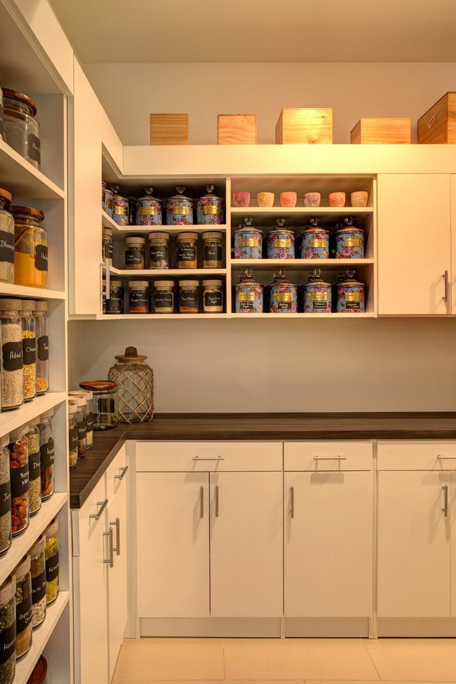 Large contemporary kitchen pantry in New York with flat-panel cabinets, white cabinets, wood benchtops and porcelain floors.