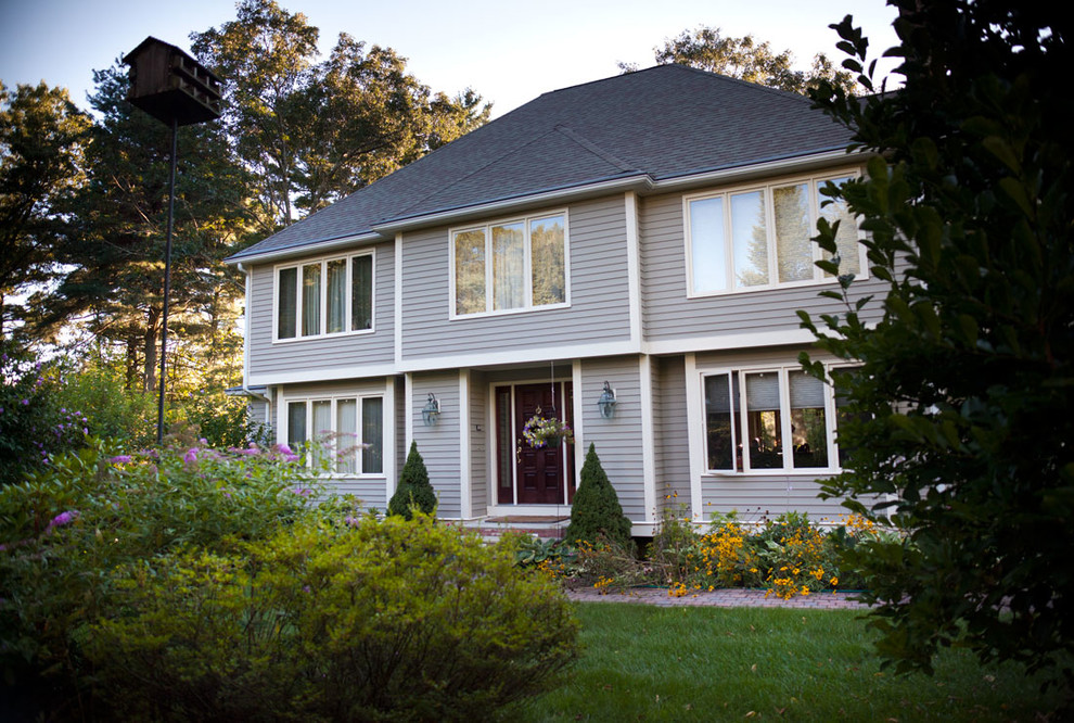 Inspiration for a mid-sized contemporary two-storey beige exterior in Boston with vinyl siding and a hip roof.