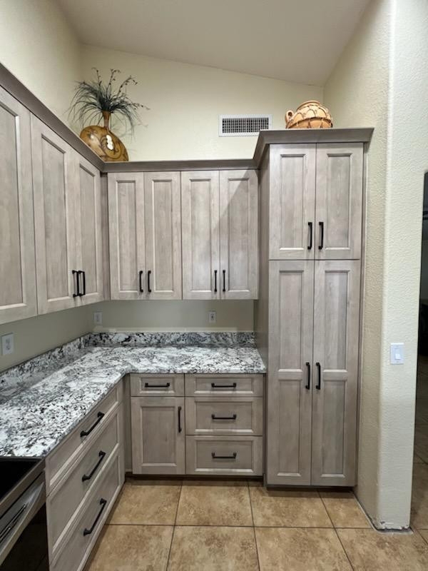 Mid-sized transitional l-shaped porcelain tile and brown floor eat-in kitchen photo in Phoenix with an undermount sink, shaker cabinets, beige cabinets, granite countertops, gray backsplash, stone slab backsplash, stainless steel appliances, an island and gray countertops