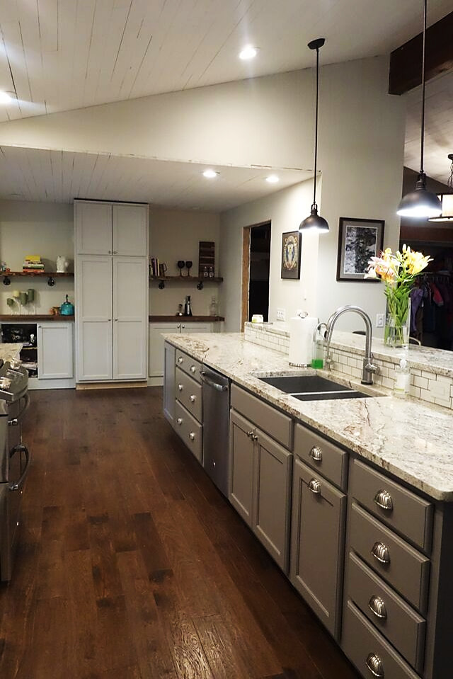 Inspiration for a mid-sized transitional galley dark wood floor eat-in kitchen remodel with an undermount sink, recessed-panel cabinets, gray cabinets, stainless steel appliances and an island