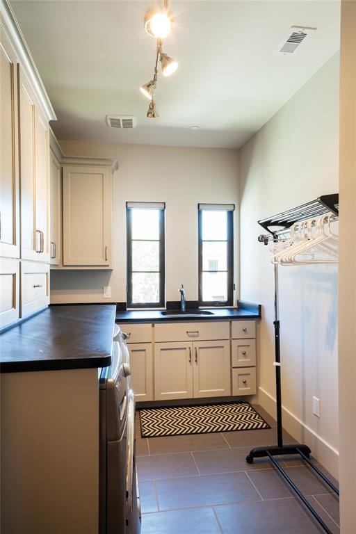 Design ideas for a large contemporary l-shaped utility room in Houston with an undermount sink, shaker cabinets, white cabinets, granite benchtops, grey walls, slate floors, a side-by-side washer and dryer, grey floor and black benchtop.